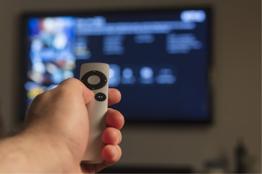 Apple TV remote in front of a streaming menu